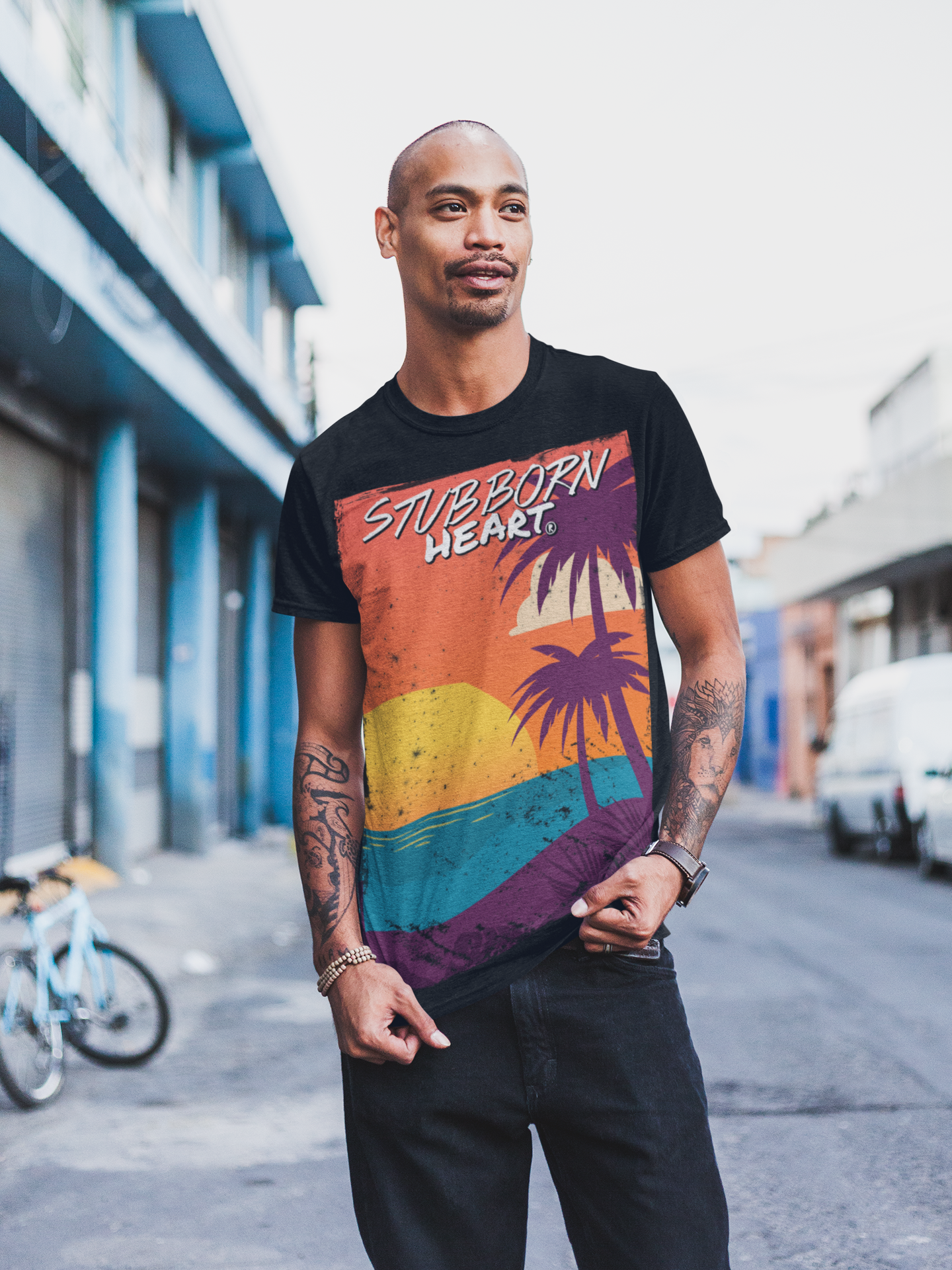 Male model wearing a black STUBBORN HEART Apparel tee design called Sunset